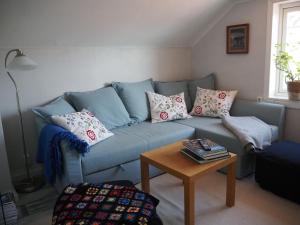 a blue couch in a living room with a table at Stenkullens gårdshus in Borensberg