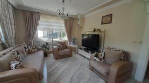 a living room with couches and a flat screen tv at grand62 in Trabzon
