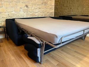 a bed sitting in a room next to a brick wall at Loft 4 chambres Montmartre Pigalle climatisé in Paris