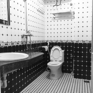 ein schwarz-weißes Bad mit WC und Waschbecken in der Unterkunft Gia Bảo Hotel in Cát Bà