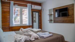 a bedroom with towels on a bed with a tv at Verde Mar Pipa Beach in Pipa +180 photos