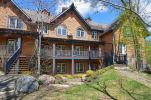 Cette grande maison en briques dispose d'une terrasse couverte et d'une cour. dans l'établissement Les Manoirs by Rendez-Vous Mont-Tremblant, à Mont-Tremblant
