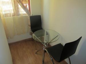 a glass table and two chairs in a room at Hotel MST Colonial in Iquique +16 photos