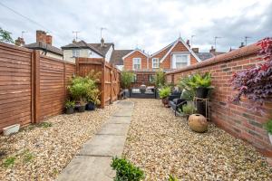 einen Hinterhof mit einem Zaun und einigen Pflanzen in der Unterkunft Stylish 3 bedroom townhouse for 5 guests, set in the medieval grid with off street parking in Bury Saint Edmunds