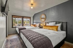 a bedroom with two beds and a mirror on the wall at Sessions Retreat & Hotel in Big Bear Lake