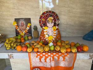 a statue of a man surrounded by fruit on a table at 5 Kesar Baug Resort in Ānjarle