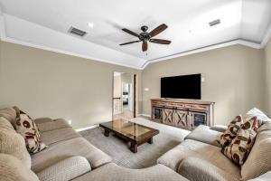 a living room with two couches and a flat screen tv at Taupewood Pl in The Woodlands