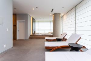 un salon avec deux chaises et un canapé dans l'établissement Parque Jockey by Viva - Prédio com fácil acesso a Pinheiros e ao Butantã, à São Paulo