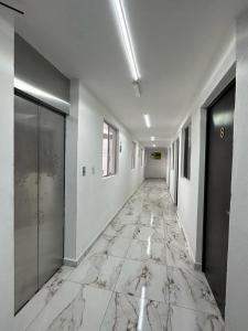 um corredor com piso em mármore num edifício em Hotel Villa 12 Orquídeas em San Juan del Río