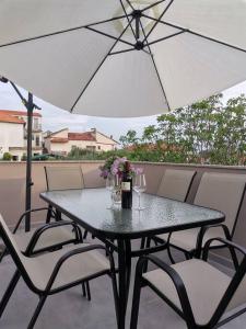 Apartment S في بيبينيا: طاولة وكراسي مع مظلة على شرفة