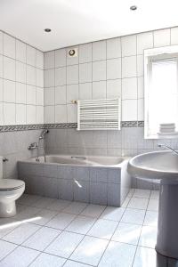 a bathroom with a tub and a toilet and a sink at Miastkovo in Poznań