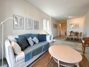 uma sala de estar com um sofá azul e uma mesa em Suite Añoreta Malaga Parking 101 em Torre de Benagalbón