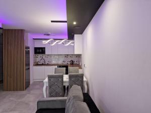 a living room with a couch and a kitchen with purple lights at Apartament Plażowa in Międzywodzie