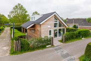 a house with a metal roof on a street at Welcome in - Vrijstaande vakantiewoning De Zonnestraal met ruime tuin - Burgh Haamstede in Burgh Haamstede