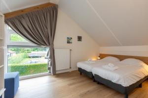 a bedroom with a bed and a large window at Welcome in - Vrijstaande vakantiewoning De Zonnestraal met ruime tuin - Burgh Haamstede in Burgh Haamstede