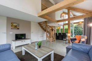 a living room with a blue couch and a table at Welcome in - Vrijstaande vakantiewoning De Zonnestraal met ruime tuin - Burgh Haamstede in Burgh Haamstede