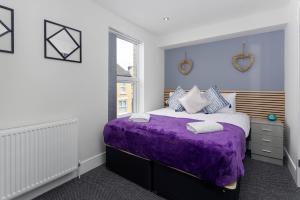 een slaapkamer met een paars bed en een raam bij Air Host and Stay - Teck House, sleeps 7, mins from Royal Hospital in Liverpool
