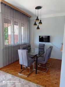 a dining room with a glass table and chairs at Mátyás király Apartman in Vonyarcvashegy