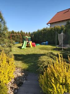 un patio trasero con un parque infantil con un tobogán en Morska Osada Swarzewo, en Swarzewo