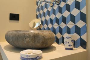 a bathroom counter with a large stone sink and vases at Tenuta Bellelli in Castellabate +153 photos