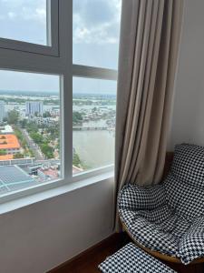 een stoel in een kamer met een groot raam bij Mộc Homestay 2 phòng ngủ in Ấp Ðông An (1)