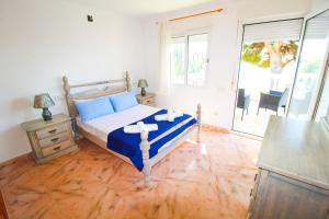 um quarto com uma cama com almofadas azuis em Great villa, Sea views, 20 secs walk to the beach, BBQ, 9 people, 5 mins car from Alicante city center, sailing club 3 mins walk em Alicante