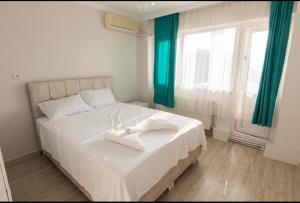 a bedroom with a large white bed with green curtains at Alpacino Apart Hotel in Istanbul