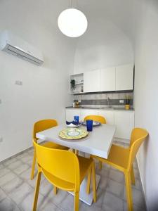 una cucina con tavolo bianco e sedie gialle di Mana House a Maiori
