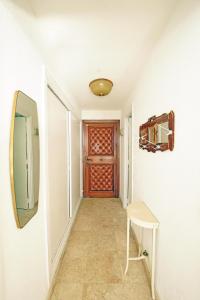 korytarz z drzwiami, stołkiem i lustrem w obiekcie Santa Clara cozy Sea view Studio w mieście Torremolinos