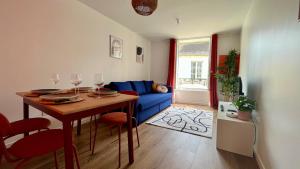 a living room with a blue couch and a table at L'artiste en duplex in Nevers
