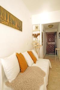 biała kanapa z pomarańczowymi poduszkami w salonie w obiekcie Santa Clara cozy Sea view Studio w mieście Torremolinos