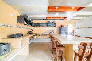 una cocina grande con encimera y sillas. en El Peregrino, en Cota