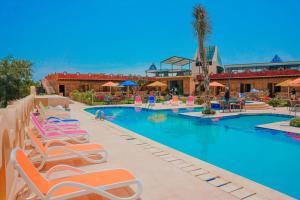 una piscina en un complejo con tumbonas en Tunis Pyramids Hotel - فندق اهرامات تونس, en Tunis