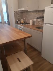 uma cozinha com uma mesa de madeira e um frigorífico branco em Casa Deva em Florença