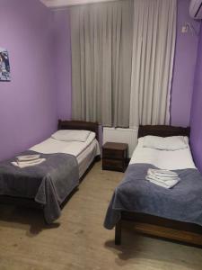 - 2 lits dans une chambre aux murs violets dans l'établissement Sweet home, à Tbilissi