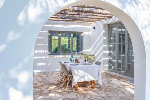 uma casa branca com uma mesa branca e cadeiras em ONLY FAMILIES Villa and Guest House with Private Pool em Chiclana de la Frontera
