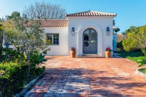 uma casa com uma entrada de tijolos e uma porta azul em ONLY FAMILIES Villa and Guest House with Private Pool em Chiclana de la Frontera