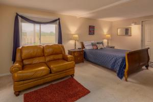 a bedroom with a couch and a bed and a window at Sweetgrass Inn Bed & Breakfast in Rapid City