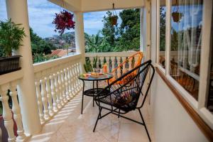 uma varanda com uma mesa e duas cadeiras em The Mbuya Residence em Kampala