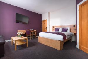 a hotel room with a bed and a desk and a tv at Fox Connaught London ExCel in London