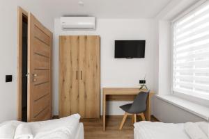クドヴァ・ズドゥルイにあるApartament Centrum Bの木製のドアと机と椅子のある寝室 +7枚の写真