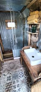 a bathroom with a white sink in a room at Down The Rabbit Hole in Waterfall