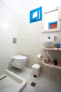 bagno bianco con servizi igienici e lavandino di Stella's place, Vlichada a Vlychada