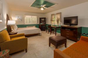 1 dormitorio con 1 cama y TV de pantalla plana en Sweetgrass Inn Bed & Breakfast, en Rapid City