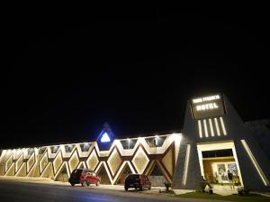 a building with cars parked in front of it at night at Tunis Pyramids Hotel - فندق اهرامات تونس in Tunis