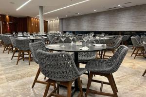 a restaurant with tables and chairs with wine glasses at SALINAS PREMIUM RESORT in Salinópolis