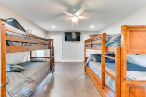 a bedroom with two bunk beds and a ceiling fan at Luxe Lake Charles Escape with Home Theater! in Lake Charles