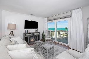 a living room with a white couch and a fireplace at The Sand Dollar at Sea Cloisters in Myrtle Beach