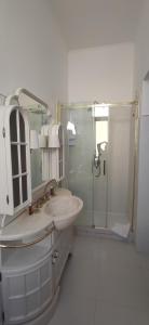 y baño blanco con lavabo y ducha. en B&B IL TEMPIO en Ladispoli