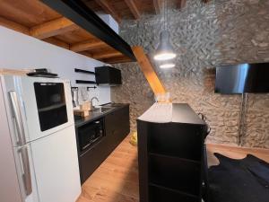 Il comprend une cuisine équipée d'un réfrigérateur blanc et d'un comptoir noir. dans l'établissement Bancalegno Sweet Dreams, à Bergame